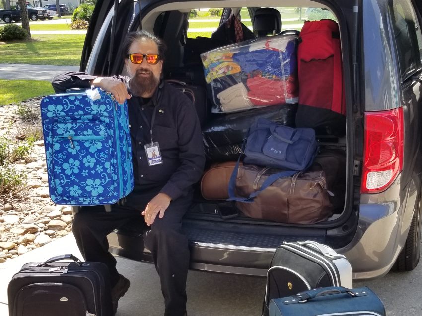 Joe Kennedy of Boys and Girls Homes of NC standing by donations of luggage, care items, supplies