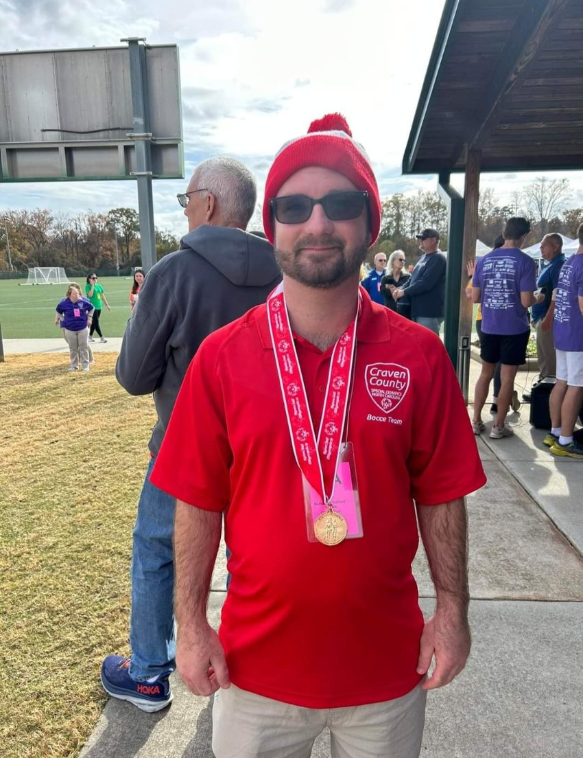 Nathan Silvers wearing red shirt and cap and his gold medal